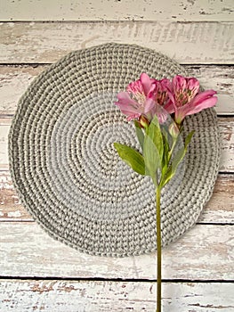 Crochet circle table runner on a wooden table with a princess lily  flower on top
