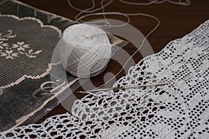 Crochet dresses and table tops, view of yarn ball and needle along with crochet patterns