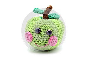 Crochet green apple with smiling face on white isolated backgro