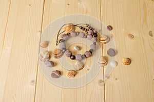 Crochet handmade beads, sea stones and seashells on a wooden tab