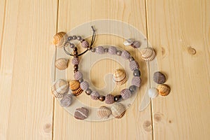 Crochet handmade beads, stones and sea shells on a light wooden