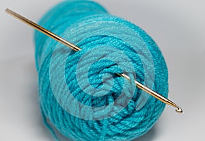 Crochet hook in skein of teal yarn