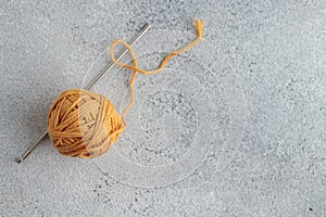 Crochet hook and a small ball of yellow yarn