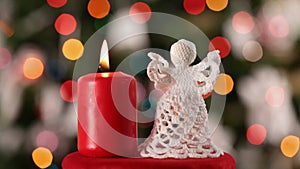 Crocheted christmas angel decoration and burning candle
