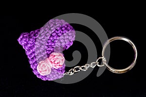 crocheted purple heart-shaped keyrings on a black background