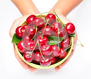 Crockery with cherries in woman hands.