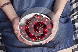 The Crockery with cherries in woman hands