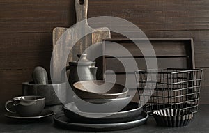 Crockery, clayware, dark utensils and stuff on dark tabletop. Kitchen still life photo