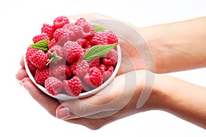 Crockery with raspberries in woman hands. photo