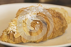 Croissant almond bread on white dish.