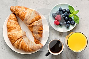 Croissant, black coffee, orange juice and fresh berries