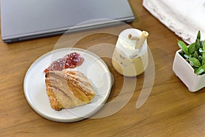 Croissant with coffee, French croissants on a plate and a cup of cabuchino coffee on wooden table background, top view