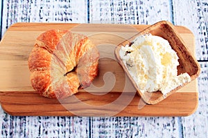 Croissant with cream cheese and bowl