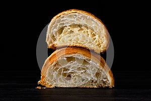 Croissant cut in a half on black background