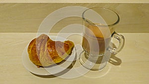 Croissant and hote chocolate at wooden table photo