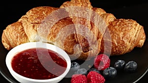 Croissant with jam and berries. Delicious and traditional breakfast. Freshly baked croissants with berries jam