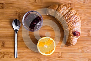 Croissant, jam and orange slice