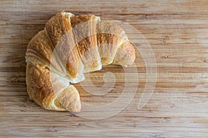 Croissant lying on wooden table