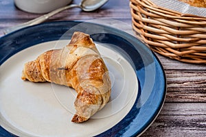 Croissant or medialuna on a small plate photo