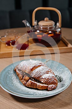 Croissant with nutella lies on a plate on the table close-up