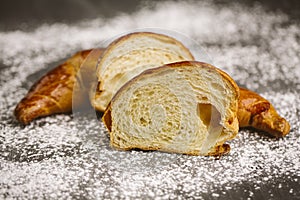 Croissant placed on a plate on a dark background.