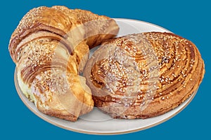 Croissant Puff Pastry Snail Rolls Sprinkled With Sesame Seeds On Blue Background photo