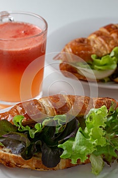 Croissant with salad, cheese and tomatoes on wooden