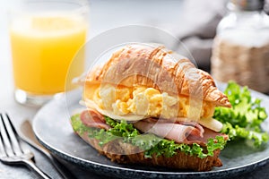 Croissant sandwich with ham, cheese, scrambled eggs