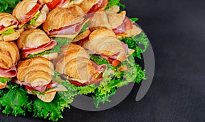 Croissant with sausage cheese and herbs on dark background