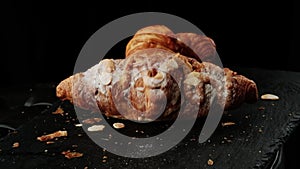 Croissant on a slate stone with dark mood background and copy space for your product.