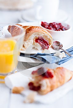 Croissant and sour cherry jam on white plates