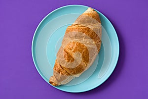Croissant on violet background. photo