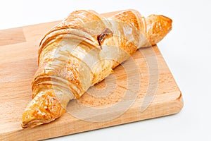 Croissant on wooden plate. white background. Top view.