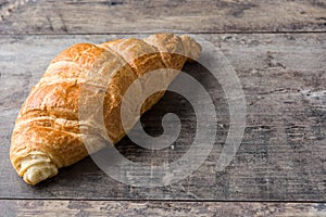 Croissant on wooden table. Copyspace photo