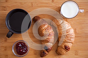 Croissants ant coffee on wooden table