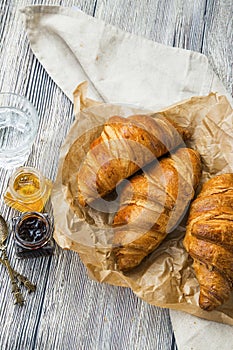 Croissants bakery, french buttery pastry with ham jars on wooden