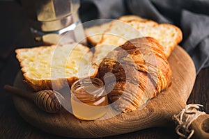 Croissants with jam on wooden board