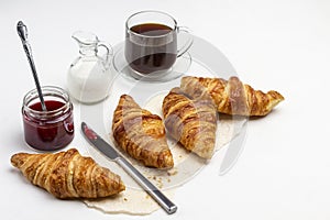 Croissants and knife on paper. Cup of coffee