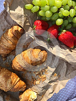 Croissants strawberries and grapes on a picnic view