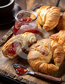 Croissants with strawberry preserves and cup of coffee photo