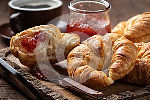 Croissants with strawberry preserves and cup of coffee photo