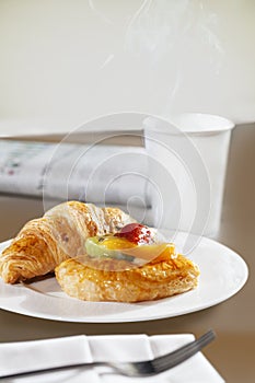Croissants and Sweet Danish Pastry, with lemon curd and fruit slices in the form of kiwi, mango, strawberry. Fresh drink