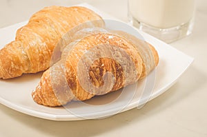 croissants in a white plate on a white table/croissants in a white square plate on a white table. Selective focus