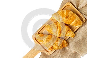 Croissants on wooden bread cutting board with sackcloth over white background. Croissant french breakfast with clipping path Top v