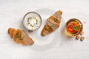 Croissants with zaatar  and labneh  on white wooden table. Top view