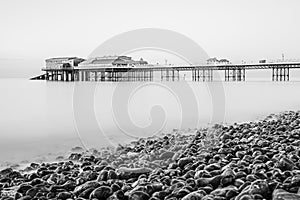 Cromer pier seen over the pebble beach in monochrome