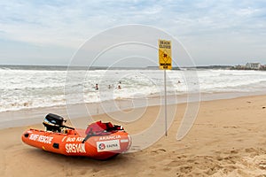 Beach closed sign and surf rescue boat at the beach in Sydney.