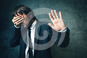 Crooked politician hiding face from photographers after political scandal