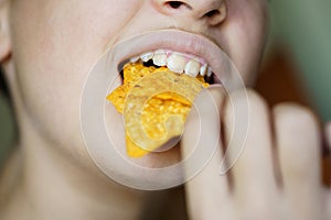 Crop anonymous girl biting yummy crunchy Mexican tortilla chips