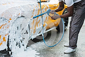 Crop close up of car washing with high pressure foam.